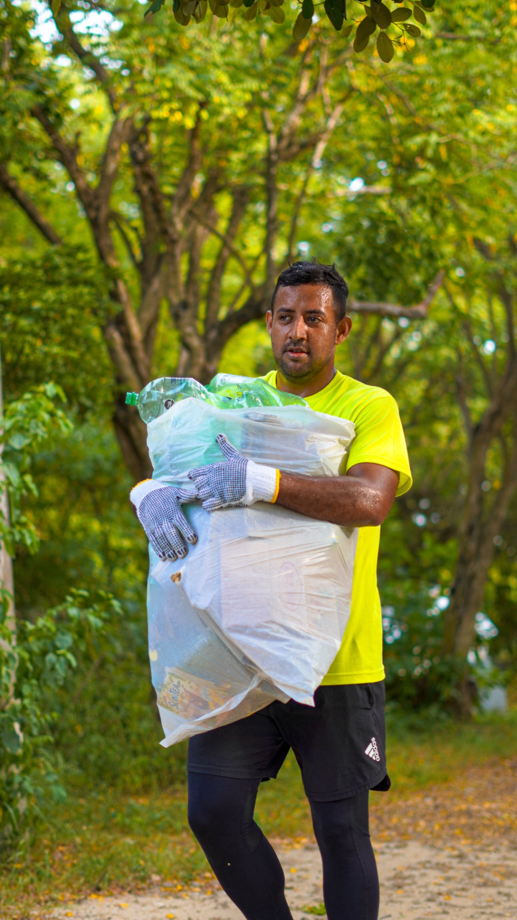 Voluntario cargando bolsa con residuos recolectados