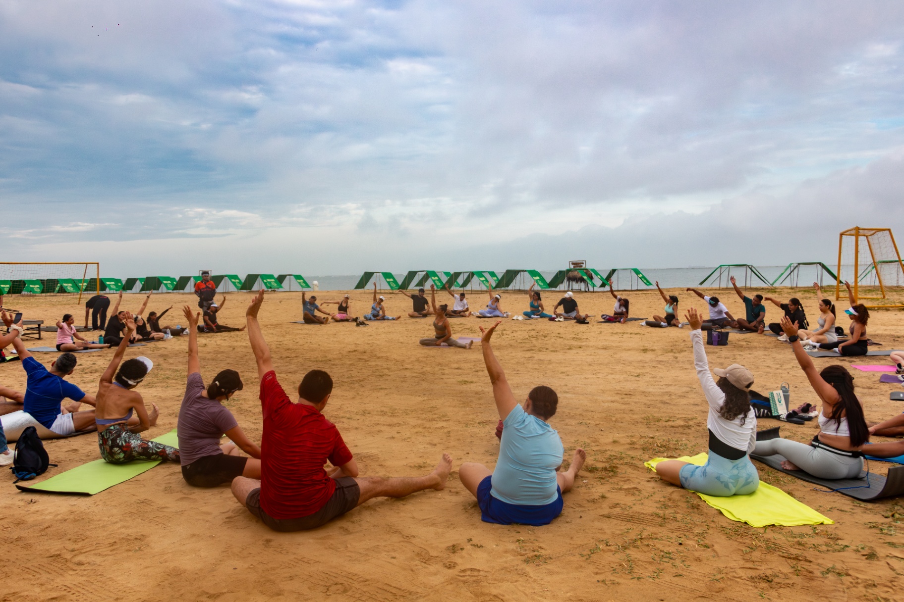 Clase de yoga colectiva en la playa
